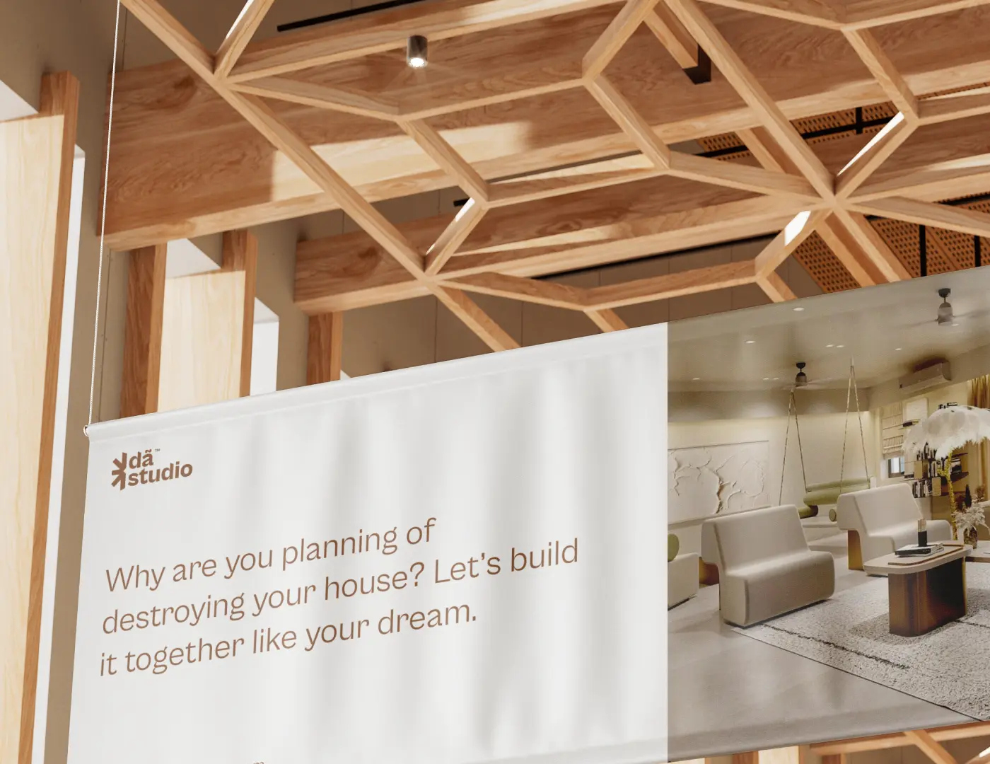 A large white hanging banner with the DA Studio logo and the text 'Why are you planning of destroying your house? Let's build it together like your dream.' inside a modern, wood-beamed interior space.