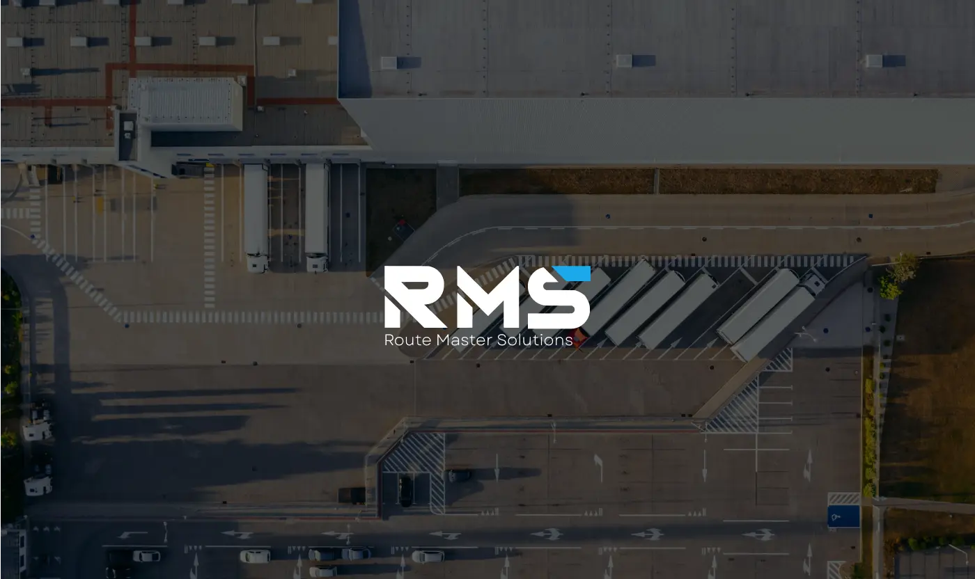 RMS Route Master Solutions white logo overlaid on an aerial view of a large logistics facility with trucks and loading docks.