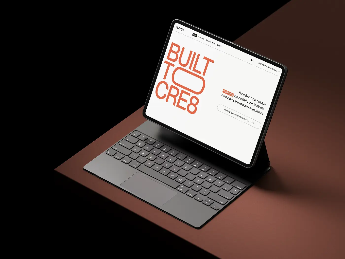 A tablet with a keyboard mockup displaying the Recre website's homepage, featuring the 'Built to Cre8' headline in orange text.