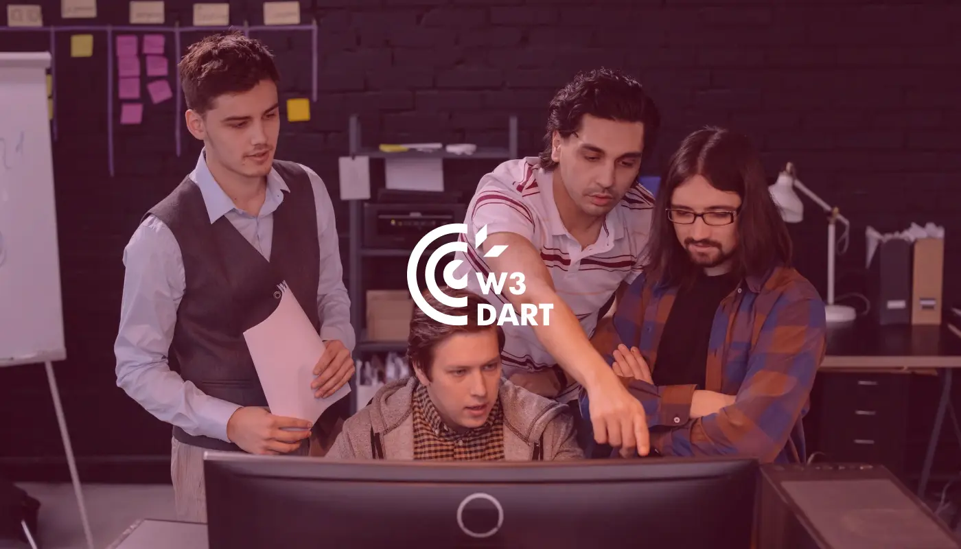 A development team of four professionals collaborating and pointing at a computer screen displaying the white W3Dart bug reporting tool logo.